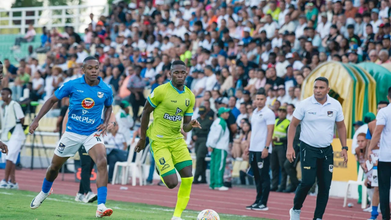 Acción de juego entre un futbolista de Orsomarso, con camiseta azul, y un jugador de Internacional FC de Palmira, con uniforme verde fluorescente, durante un partido anterior.