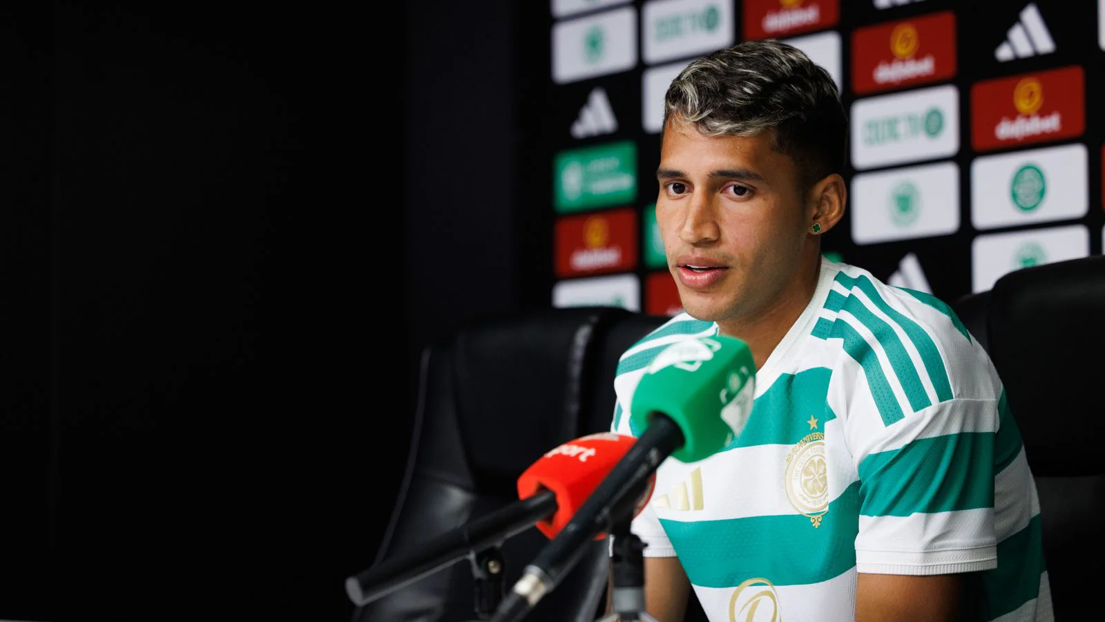 Camilo Durán responde a los medios en una rueda de prensa del Celtic; viste la camiseta verdiblanca del club.