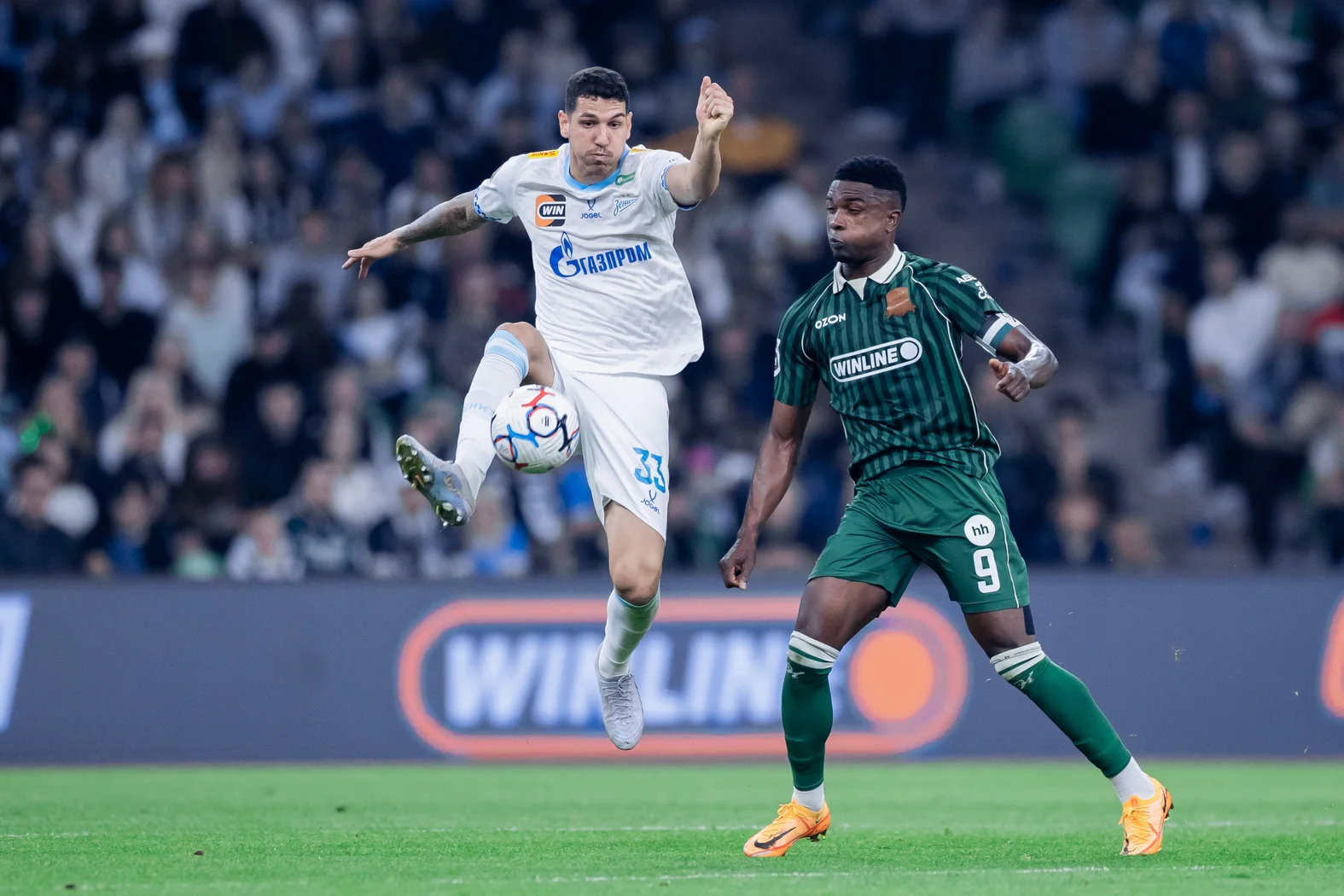 Jhon Córdoba, con el número 9 del Krasnodar, disputa el balón ante un jugador del Zenit.