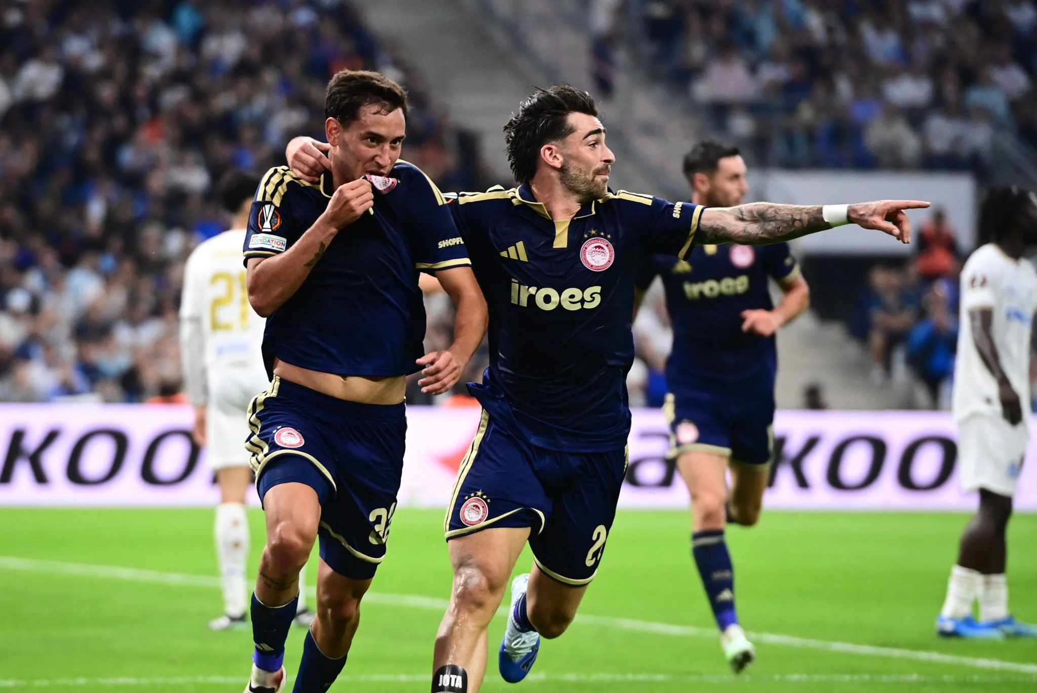 Dos jugadores de Olympiacos se abrazan durante la celebración en el estadio de Marseille